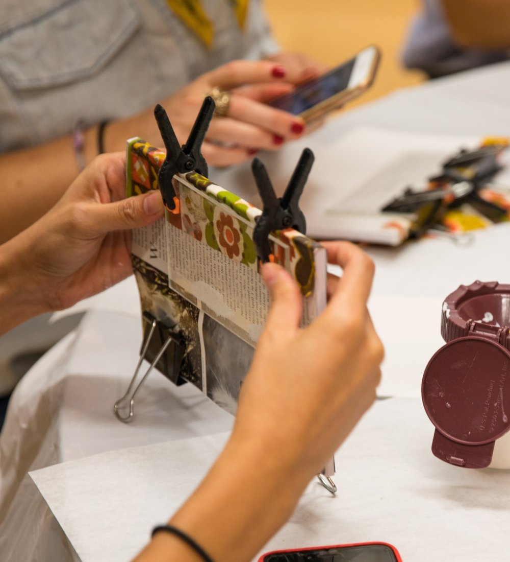 Image of a woman binding a book at an interactive workshop by Mingei International Museum