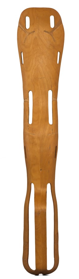This “plyformed wood” leg splint was designed as a valuable contribution to World War II by Charles and Ray Eames. It was made from one piece of wood bonded by resin glue and shaped by heat and pressure. This splint was designed to fit the shape of the user's buttocks, thigh, calf, and heel.