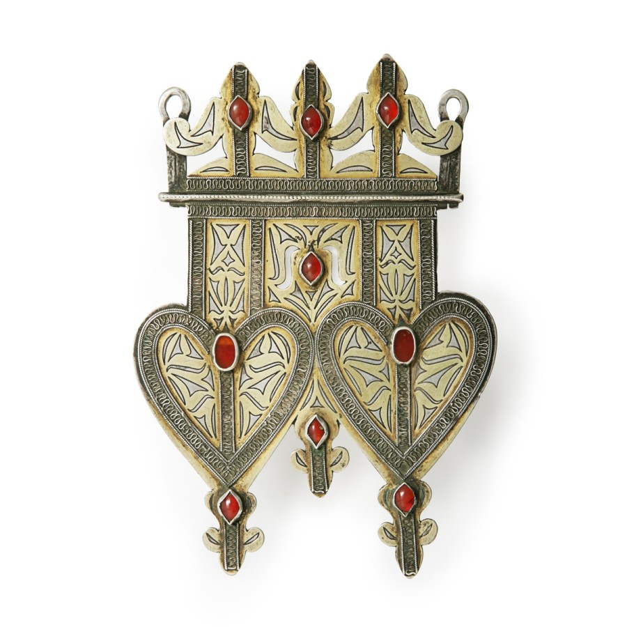 This pendant is made of gold, silver and carnelians. It is symmetrical with designs such two large heart and crosses.