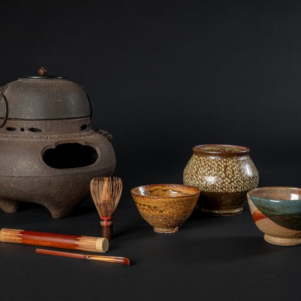 Objects for Japanese Matcha tea from Mingei International Museum's permanent collection.
Image description: Various colorful tea instruments, including tea bowls, a water jar, chasen, matcha scoop, and brazier against a black background.