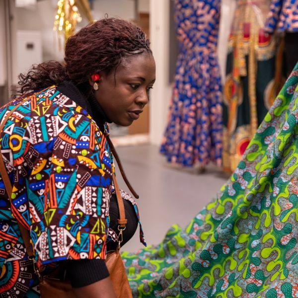 A woman looking at a large piece of African fabric.